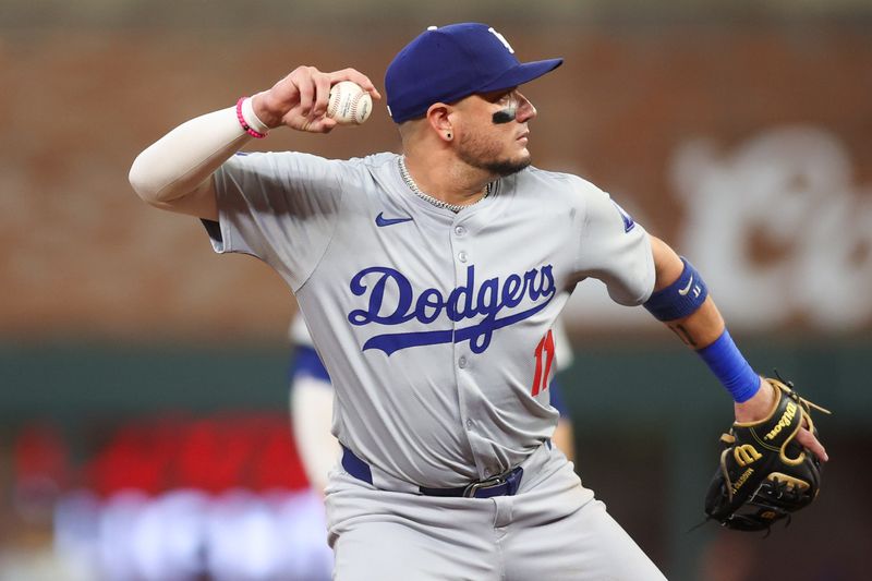 Sep 13, 2024; Atlanta, Georgia, USA; Los Angeles Dodgers shortstop Miguel Rojas (11) throws a runner out at first against the Atlanta Braves in the third inning at Truist Park. Mandatory Credit: Brett Davis-Imagn Images