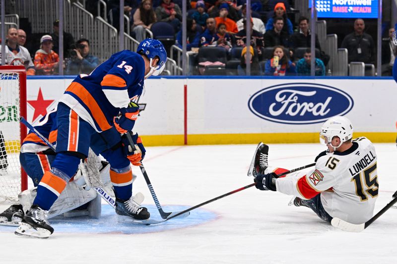 Oct 26, 2024; Elmont, New York, USA;  New York Islanders center Bo Horvat (14) defends against Florida Panthers center Anton Lundell (15) in front of New York Islanders goaltender Semyon Varlamov (40) during the first period at UBS Arena. Mandatory Credit: Dennis Schneidler-Imagn Images