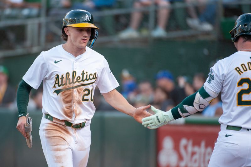 Jun 18, 2024; Oakland, California, USA; Oakland Athletics second base Zack Gelof (20) celebrates with team mates after scoring against the Kansas City Royals during the third inning at Oakland-Alameda County Coliseum. Mandatory Credit: Ed Szczepanski-USA TODAY Sports