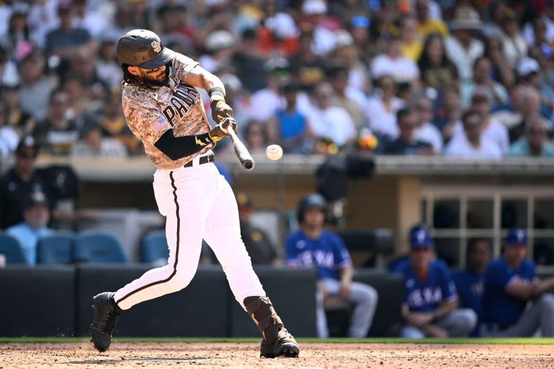 Jul 30, 2023; San Diego, California, USA; San Diego Padres right fielder Fernando Tatis (23) hits an RBI single against the Texas Rangers during the eighth inning at Petco Park. Mandatory Credit: Orlando Ramirez-USA TODAY Sports