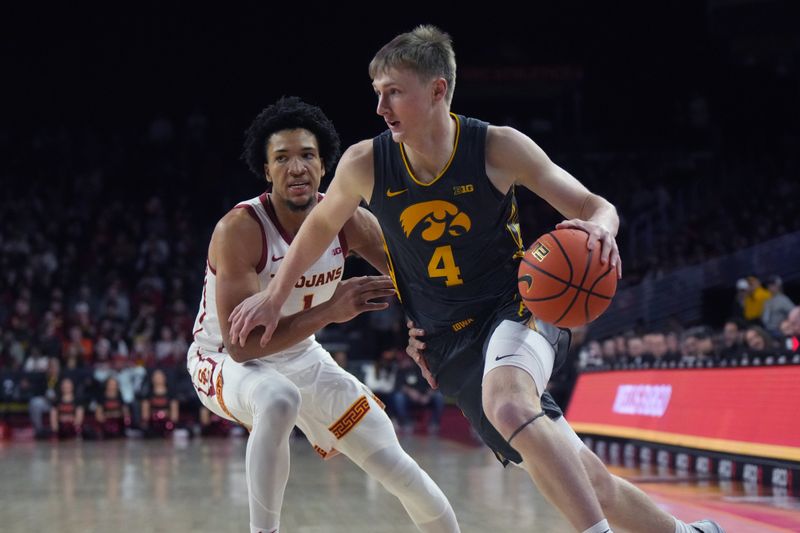 Jan 14, 2025; Los Angeles, California, USA; Iowa Hawkeyes guard Josh Dix (4) dribbles the ball against Southern California Trojans guard Desmond Claude (1) in the first half at Galen Center. Mandatory Credit: Kirby Lee-Imagn Images