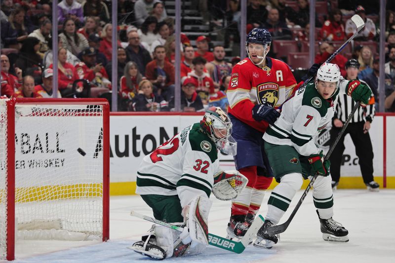 Oct 22, 2024; Sunrise, Florida, USA; Florida Panthers left wing Matthew Tkachuk (19) watches as Minnesota Wild goaltender Filip Gustavsson (32) makes a save during the second period at Amerant Bank Arena. Mandatory Credit: Sam Navarro-Imagn Images