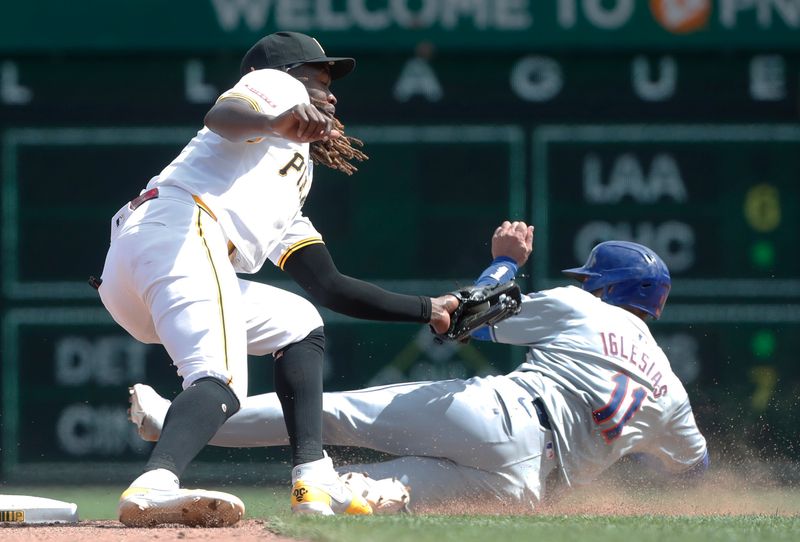 Jul 7, 2024; Pittsburgh, Pennsylvania, USA;  New York Mets second baseman Jose Iglesias (11) is out on a steal attempt at second base as Pittsburgh Pirates shortstop Oneil Cruz (15) applies a tag during the eighth inning at PNC Park. The Mets won 3-2. Mandatory Credit: Charles LeClaire-USA TODAY Sports
