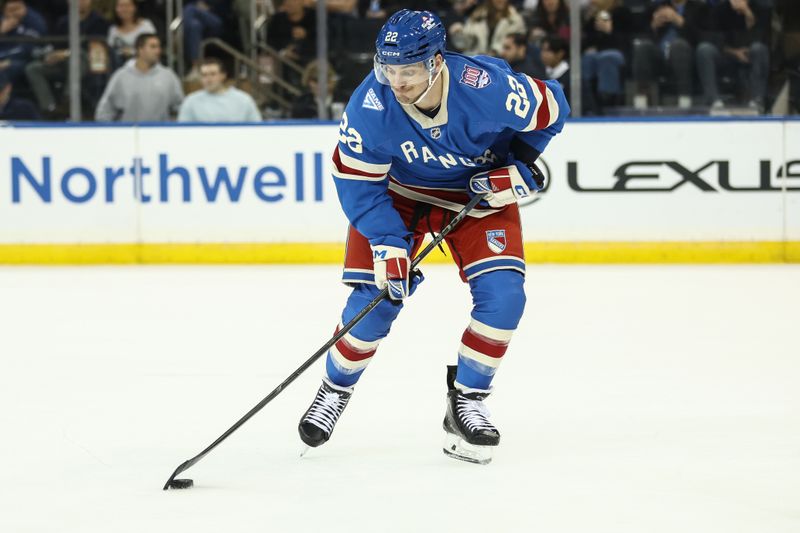 Nov 8, 2025; New York, New York, USA;  New York Rangers center Jonny Brodzinski (22) controls the puck in the third period against the New York Islanders at Madison Square Garden. Mandatory Credit: Wendell Cruz-Imagn Images