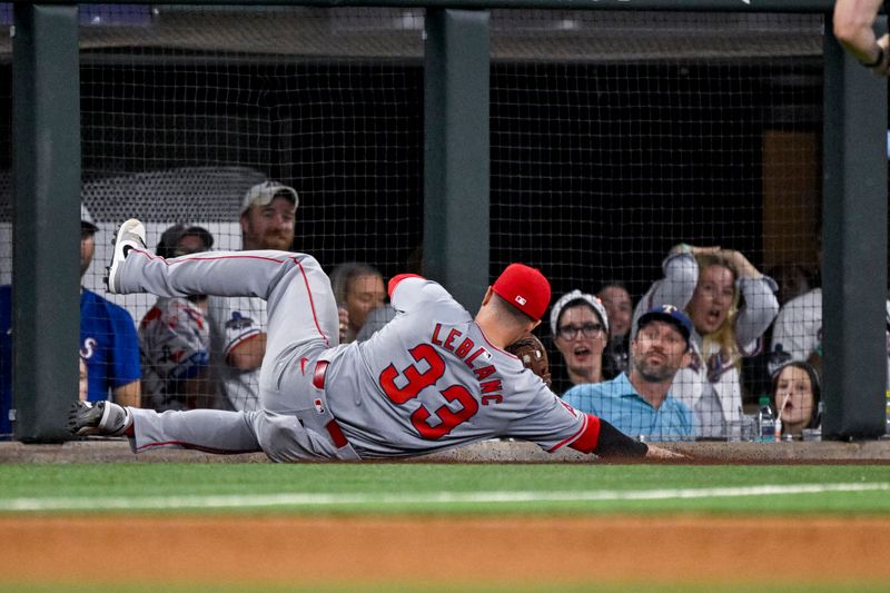 Sep 5, 2024; Arlington, Texas, USA; Los Angeles Angels third baseman Charles Leblanc (33) makes a sliding catch of foul ball hit by Texas Rangers third baseman Josh Jung (6) during the game at Globe Life Field. Mandatory Credit: Jerome Miron-Imagn Images