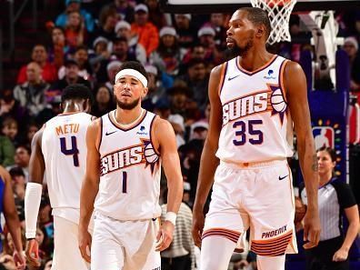 PHOENIX, AZ - DECEMBER 25: Kevin Durant #35 and Devin Booker #1 of the Phoenix Suns look on during the game against the Dallas Mavericks on December 25, 2023 at Footprint Center in Phoenix, Arizona. NOTE TO USER: User expressly acknowledges and agrees that, by downloading and or using this photograph, user is consenting to the terms and conditions of the Getty Images License Agreement. Mandatory Copyright Notice: Copyright 2023 NBAE (Photo by Barry Gossage/NBAE via Getty Images)