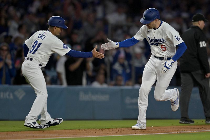 May 20, 2024; Los Angeles, California, USA;  Los Angeles Dodgers first baseman Freddie Freeman (5) is greeted by third base coach Dino Ebel (91) as he rounds the bases after hitting a grand slam home run in the third inning against the Arizona Diamondbacks at Dodger Stadium. Mandatory Credit: Jayne Kamin-Oncea-USA TODAY Sports