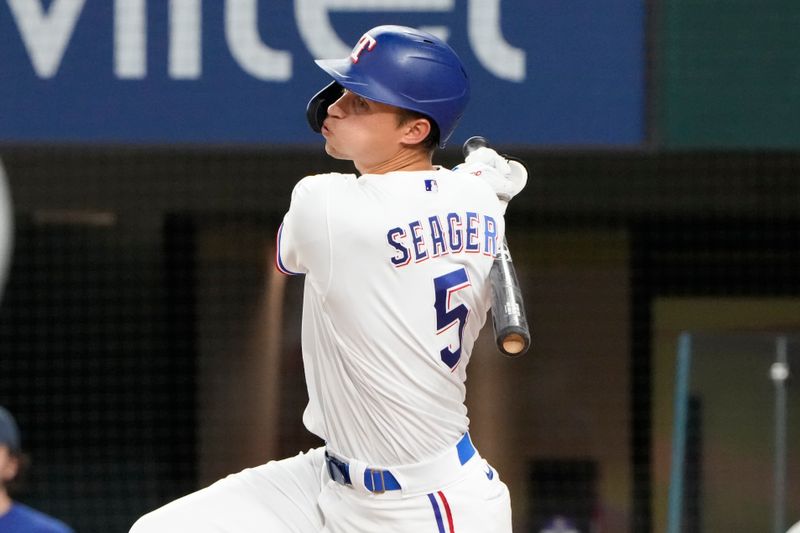 Apr 14, 2022; Arlington, Texas, USA; Texas Rangers shortstop Corey Seager (5) follows through on his RBI single against the Los Angeles Angels during the fifth inning of a baseball game at Globe Life Field. Mandatory Credit: Jim Cowsert-USA TODAY Sports