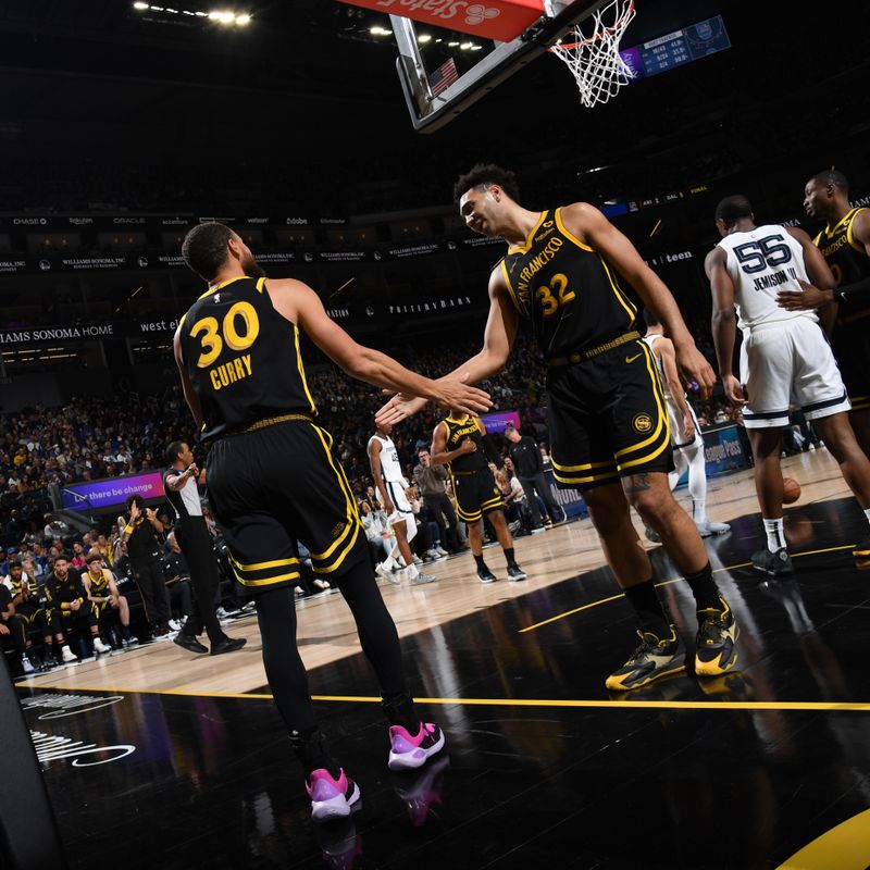 SAN FRANCISCO, CA - MARCH 20: Stephen Curry #30 and Trayce Jackson-Davis #32 of the Golden State Warriors  high five during the game against the Memphis Grizzlies on March 20, 2024 at Chase Center in San Francisco, California. NOTE TO USER: User expressly acknowledges and agrees that, by downloading and or using this photograph, user is consenting to the terms and conditions of Getty Images License Agreement. Mandatory Copyright Notice: Copyright 2024 NBAE (Photo by Noah Graham/NBAE via Getty Images)