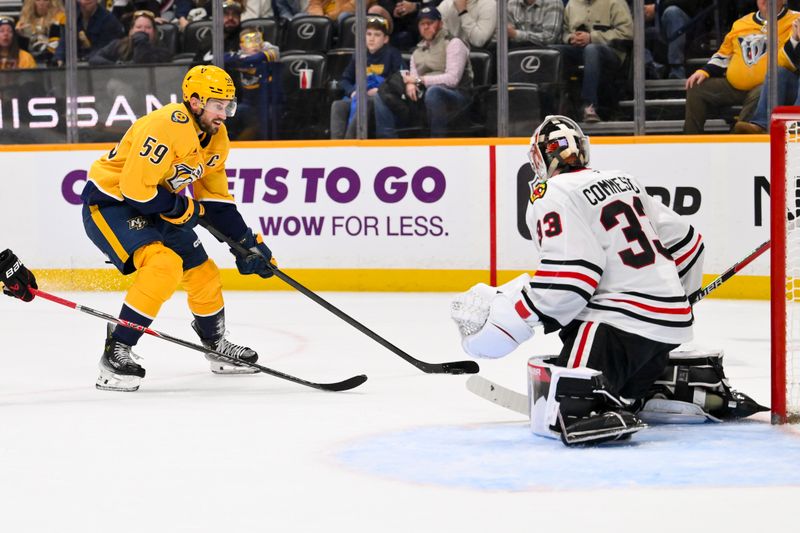 Jan 10, 2026; Nashville, Tennessee, USA;  Chicago Blackhawks goaltender Drew Commesso (33) blocks the shot of Nashville Predators defenseman Roman Josi (59) during the third period at Bridgestone Arena. Mandatory Credit: Steve Roberts-Imagn Images