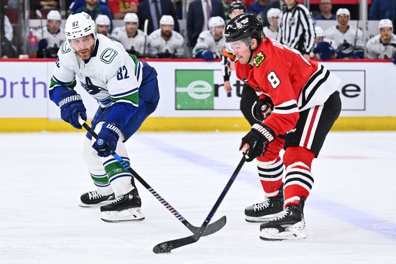 Feb 13, 2024; Chicago, Illinois, USA; Vancouver Canucks defenseman Ian Cole (82) defends as Chicago Blackhawks forward Ryan Donato (8) takes control of the puck in the third period at United Center. Mandatory Credit: Jamie Sabau-USA TODAY Sports