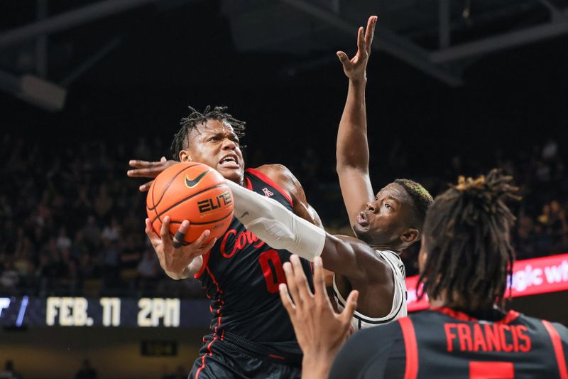 Jan 25, 2023; Orlando, Florida, USA; Houston Cougars guard Marcus Sasser (0) is fouled by UCF Knights forward Lahat Thioune (0) during the second half at Addition Financial Arena. Mandatory Credit: Mike Watters-USA TODAY Sports