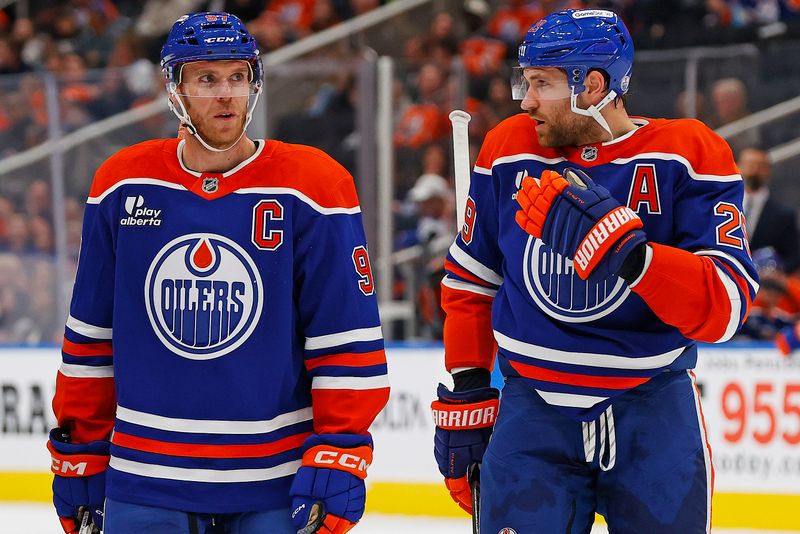 Sep 24, 2025; Edmonton, Alberta, CAN; Edmonton Oilers forward Connor McDavid (97) and forward Leon Draisaitl (29) discuss a play during a break in play against the Seattle Kraken at Rogers Place. Mandatory Credit: Perry Nelson-Imagn Images