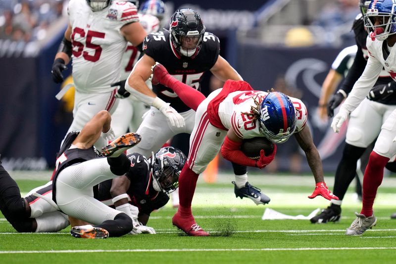 New York Giants running back Eric Gray (20) is tackled as he runs the ball by Houston Texans cornerback Myles Bryant, left, in the second half of a preseason NFL football game, Saturday, Aug. 17, 2024, in Houston. (AP Photo/Eric Gay)