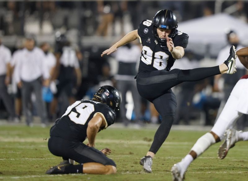 Nov 14, 2020; Orlando, Florida, USA; UCF Knights place kicker Daniel Obarski (98) kicks an extra point from the hold of punter Alan Kervin (99) during the second half against the Temple Owls at the Bounce House. Mandatory Credit: Reinhold Matay-USA TODAY Sports