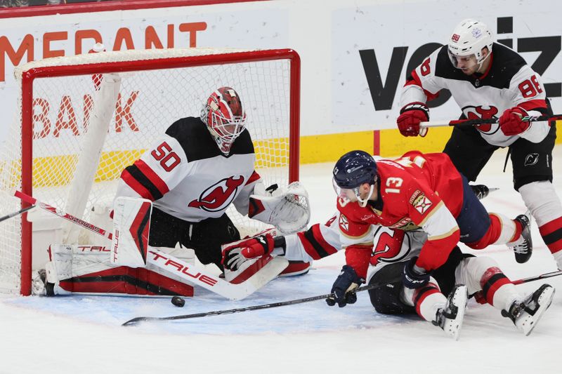 Jan 13, 2024; Sunrise, Florida, USA; New Jersey Devils goaltender Nico Daws (50) makes save against Florida Panthers center Sam Reinhart (13) during the third period at Amerant Bank Arena. Mandatory Credit: Sam Navarro-USA TODAY Sports