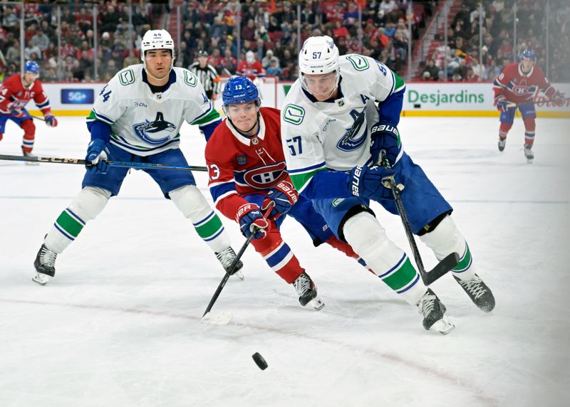 Jan 6, 2025; Montreal, Quebec, CAN; Vancouver Canucks defenseman Tyler Myers (57) plays the puck and Montreal Canadiens forward Cole Caufield (13) forechecks during the second period at the Bell Centre. Mandatory Credit: Eric Bolte-Imagn Images