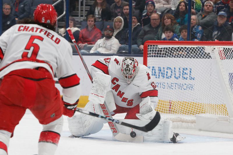 Dec 31, 2024; Columbus, Ohio, USA; Carolina Hurricanes goalie Pyotr Kochetkov (52) makes a save against the Columbus Blue Jackets during the first period at Nationwide Arena. Mandatory Credit: Russell LaBounty-Imagn Images