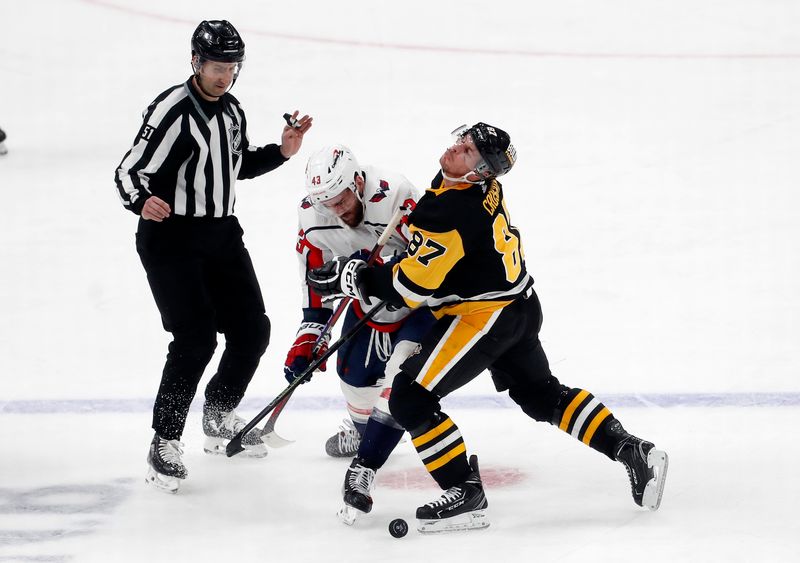 Jan 2, 2024; Pittsburgh, Pennsylvania, USA;  Washington Capitals right wing Tom Wilson (43) checks Pittsburgh Penguins center Sidney Crosby (87) during the third period at PPG Paints Arena. Mandatory Credit: Charles LeClaire-USA TODAY Sports