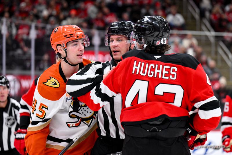Dec 13, 2025; Newark, New Jersey, USA; NHL referee Brandon Blandina (39) breaks up a scuffle between Anaheim Ducks right wing Beckett Sennecke (45) and New Jersey Devils defenseman Luke Hughes (43) during the third period at Prudential Center. Mandatory Credit: John Jones-Imagn Images