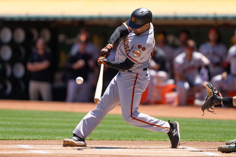 Aug 6, 2023; Oakland, California, USA;  San Francisco Giants first baseman LaMonte Wade Jr. (31) hits a single during the first inning against the Oakland Athletics at Oakland-Alameda County Coliseum. Mandatory Credit: Stan Szeto-USA TODAY Sports