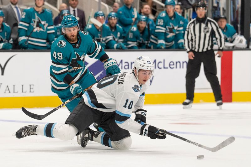 Oct 1, 2024; San Jose, California, USA;  Utah Hockey Club defenseman Maveric Lamoureux (10) falls in front of San Jose Sharks right wing Scott Sabourin (49) during the first period at SAP Center at San Jose. Mandatory Credit: Stan Szeto-Imagn Images
