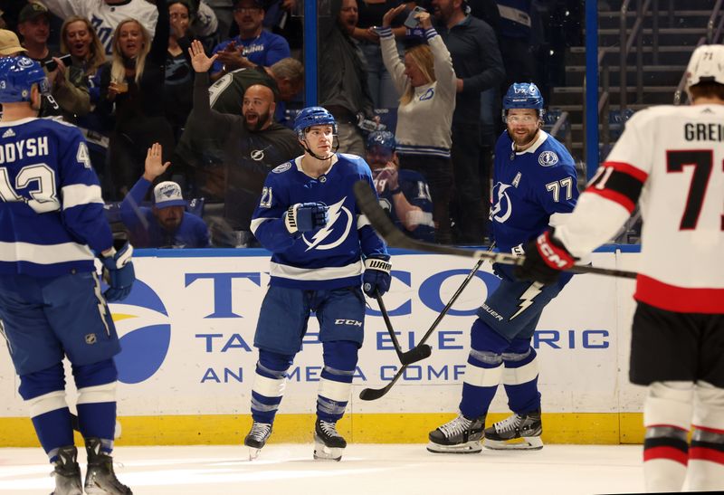 Apr 11, 2024; Tampa, Florida, USA; Tampa Bay Lightning center Brayden Point (21) is congratulated by defenseman Victor Hedman (77) and defenseman Darren Raddysh (43) after he scored a goal against the Ottawa Senators during the first period at Amalie Arena. Mandatory Credit: Kim Klement Neitzel-USA TODAY Sports