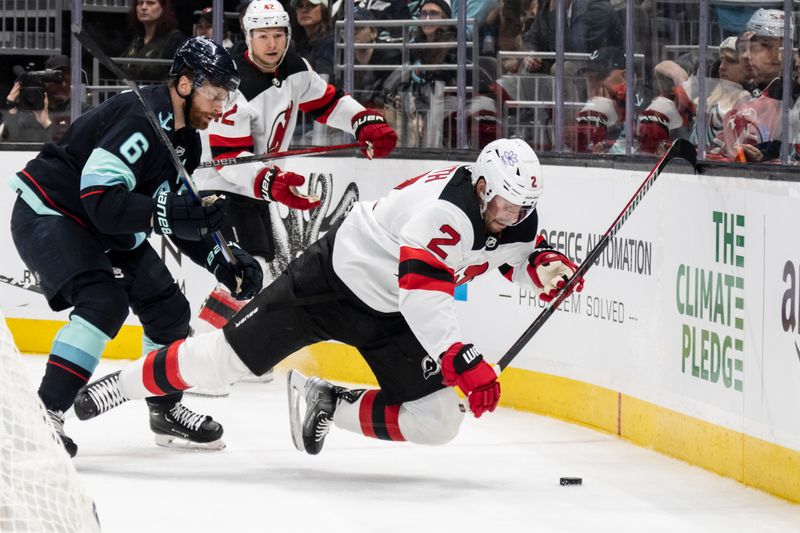 Dec 7, 2023; Seattle, Washington, USA; New Jersey Devils defenseman Brendan Smith (2) is shoved to the ice by Seattle Kraken defenseman Adam Larsson (6) during the first period at Climate Pledge Arena. Mandatory Credit: Stephen Brashear-USA TODAY Sports