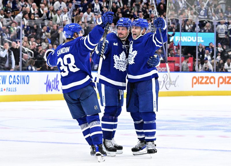 Oct 13, 2022; Toronto, Ontario, CAN;  Toronto Maple Leafs forward Auston Matthews (34) celebrates with defensemen Mark Giordano (55) and Rasmus Sandin (38) after scoring against the Washington Capitals in the third period at Scotiabank Arena. Mandatory Credit: Dan Hamilton-USA TODAY Sports