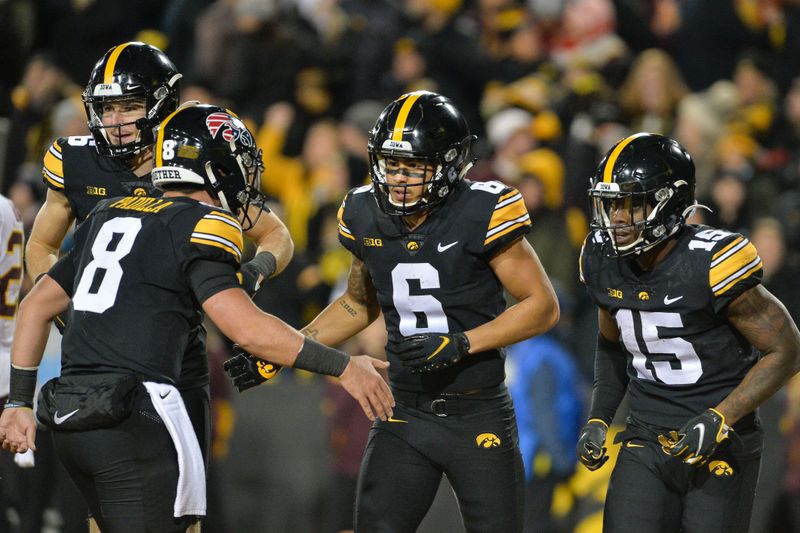 Nov 13, 2021; Iowa City, Iowa, USA; Iowa Hawkeyes wide receiver Keagan Johnson (6) celebrates with quarterback Alex Padilla (8) and running back Tyler Goodson (15) and wide receiver Charlie Jones (left) after scoring a touchdown against the Minnesota Golden Gophers during the fourth quarter at Kinnick Stadium. Mandatory Credit: Jeffrey Becker-USA TODAY Sports