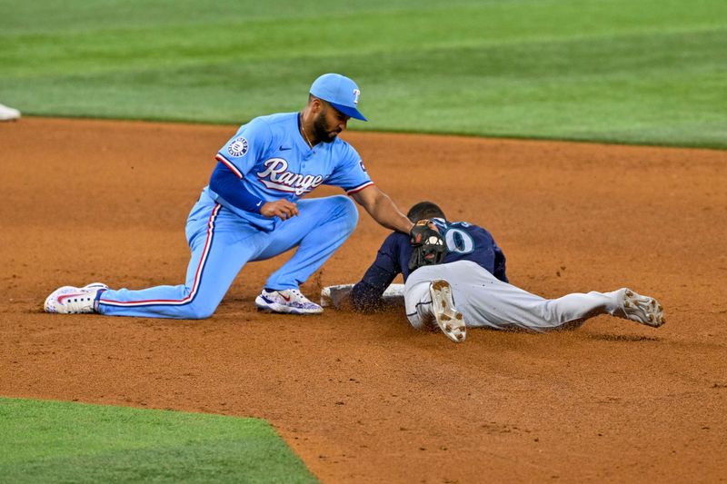 Sep 22, 2024; Arlington, Texas, USA; Seattle Mariners right fielder Victor Robles (10) slides under the tag of Texas Rangers second baseman Marcus Semien (2) during the sixth inning at Globe Life Field. Mandatory Credit: Jerome Miron-Imagn Images