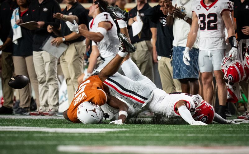 Oct 19, 2024; Austin, Texas, USA; Texas Longhorns wide receiver Ryan Wingo (5) and Georgia Bulldogs defensive back Daylen Everette (6) hit the turf after a mid-air collision in the first quarter at Darrell K. Royal Texas Memorial Stadium. Mandatory Credit: Sara Diggins/USA TODAY Network via Imagn Images