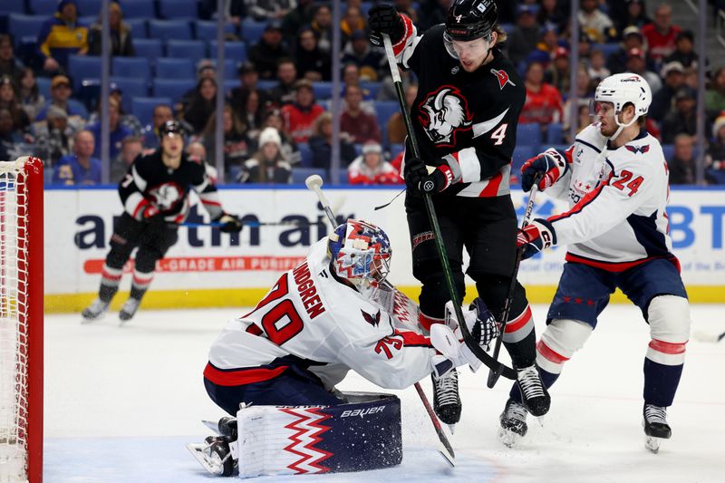 Jan 6, 2025; Buffalo, New York, USA;  Buffalo Sabres defenseman Bowen Byram (4) jumps to avoid a shot as Washington Capitals goaltender Charlie Lindgren (79) makes a glove save during the third period at KeyBank Center. Mandatory Credit: Timothy T. Ludwig-Imagn Images