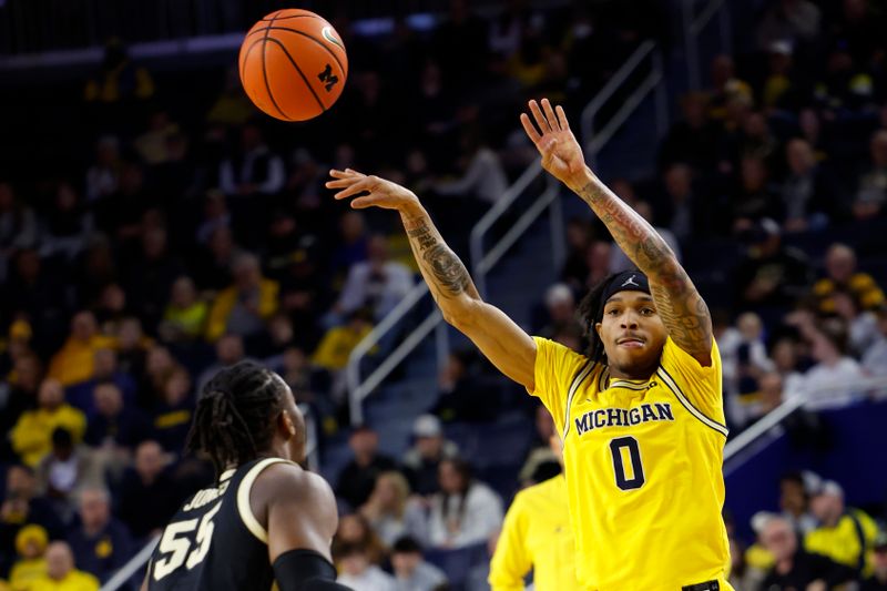 Feb 25, 2024; Ann Arbor, Michigan, USA;  Michigan Wolverines guard Dug McDaniel (0) passes over Purdue Boilermakers guard Lance Jones (55) in the first half at Crisler Center. Mandatory Credit: Rick Osentoski-USA TODAY Sports