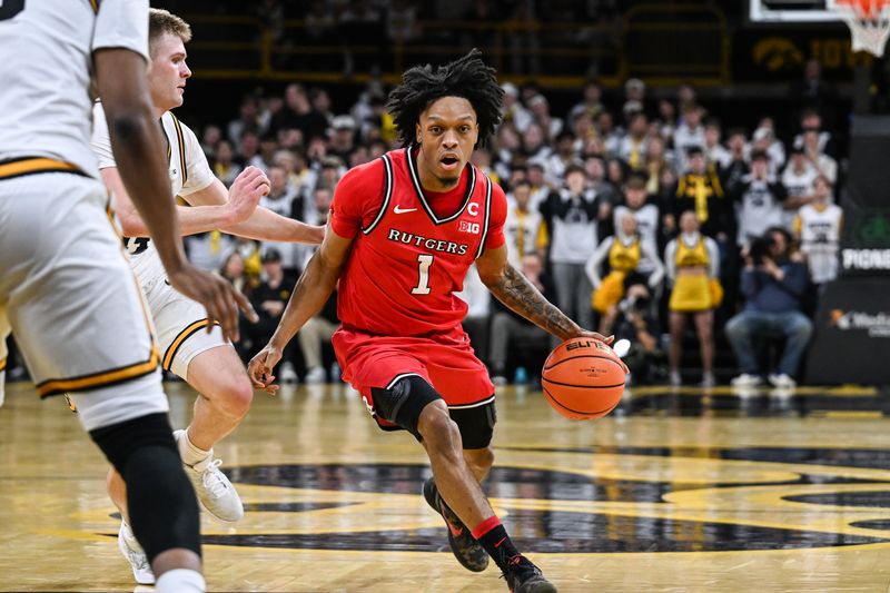 Jan 20, 2026; Iowa City, Iowa, USA; Rutgers Scarlet Knights guard Jamichael Davis (1) controls the ball as Iowa Hawkeyes guard Bennett Stirtz (14) defends during the first half at Carver-Hawkeye Arena. Mandatory Credit: Jeffrey Becker-Imagn Images