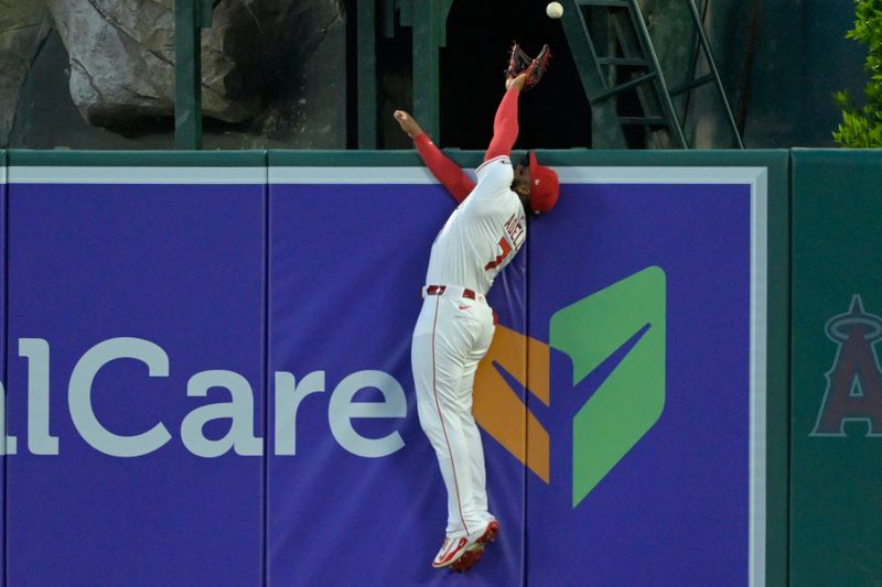 Apr 5, 2025; Anaheim, California, USA;  Los Angeles Angels center fielder Jo Adell (7) leaps for the home run ball hit by Cleveland Guardians catcher Bo Naylor (23) in the third inning at Angel Stadium. Mandatory Credit: Jayne Kamin-Oncea-Imagn Images