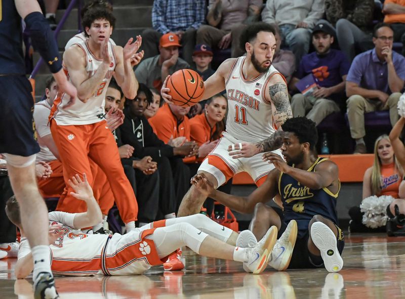 Feb 26, 2025; Clemson, South Carolina, USA; Clemson guard Jaeden Zachery (11) takes a loose ball away from Notre Dame guard Sir Mohammed (4) near Clemson guard Jake Heidbreder (3) during the first half at Littlejohn Coliseum. Mandatory Credit: Ken Ruinard-Imagn Images
