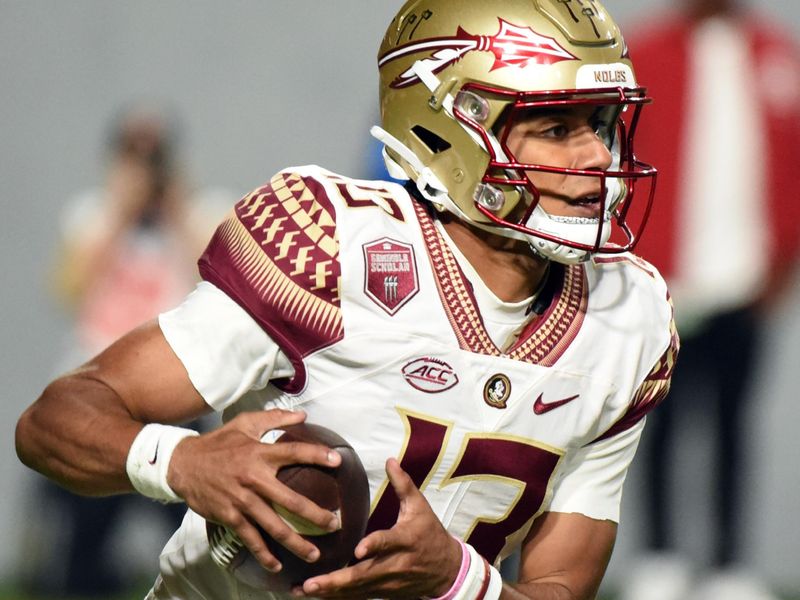 Oct 8, 2022; Raleigh, North Carolina, USA; Florida State Seminoles quarterback Jordan Travis (13) runs the ball during the first half against the North Carolina State Wolfpack at Carter-Finley Stadium. Mandatory Credit: Rob Kinnan-USA TODAY Sports