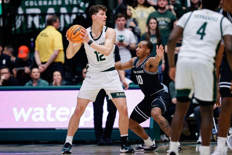 Feb 17, 2024; Fort Collins, Colorado, USA; Colorado State Rams forward Patrick Cartier (12) controls the ball as Utah State Aggies guard Darius Brown II (10) guards in the first half at Moby Arena. Mandatory Credit: Isaiah J. Downing-USA TODAY Sports