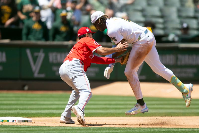 Jul 20, 2024; Oakland, California, USA; Los Angeles Angels third baseman Anthony Rendon (6) tags out Oakland Athletics right fielder Lawrence Butler (4) as he tries to stretch a double into a triple during the fourth inning at Oakland-Alameda County Coliseum. Mandatory Credit: D. Ross Cameron-USA TODAY Sports