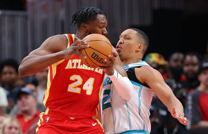 ATLANTA, GEORGIA - APRIL 10:  Grant Williams #2 of the Charlotte Hornets draws an offensive foul from Bruno Fernando #24 of the Atlanta Hawks during the fourth quarter at State Farm Arena on April 10, 2024 in Atlanta, Georgia.  NOTE TO USER: User expressly acknowledges and agrees that, by downloading and/or using this photograph, user is consenting to the terms and conditions of the Getty Images License Agreement.  (Photo by Kevin C. Cox/Getty Images)