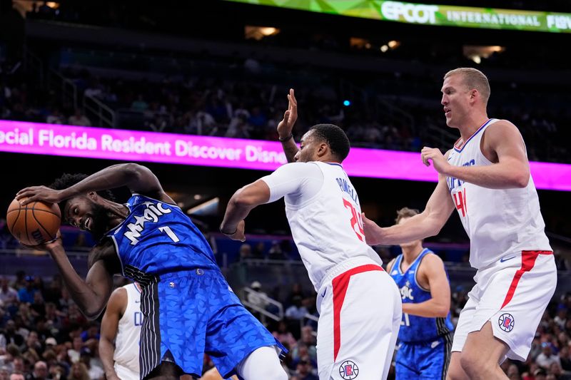 ORLANDO, FLORIDA - MARCH 29: Norman Powell #24 of the Los Angeles Clippers fouls Jonathan Isaac #1 of the Orlando Magic during the second quarter at Kia Center on March 29, 2024 in Orlando, Florida. NOTE TO USER: User expressly acknowledges and agrees that, by downloading and or using this photograph, User is consenting to the terms and conditions of the Getty Images License Agreement. (Photo by Rich Storry/Getty Images)