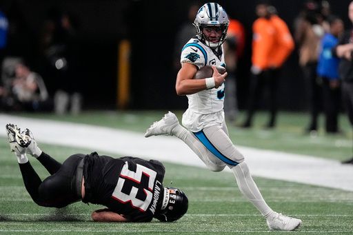 Carolina Panthers quarterback Bryce Young (9) runs past Atlanta Falcons linebacker Nate Landman (53) during the second half of an NFL football game against the Carolina Panthers, Sunday, Jan. 5, 2025, in Atlanta. (AP Photo/Mike Stewart)