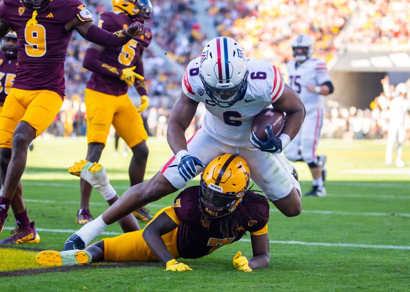 Nov 25, 2023; Tempe, Arizona, USA; Arizona Wildcats running back Michael Wiley (6) scores a touchdown over Arizona State Sun Devils defensive back Shamari Simmons (7) during the Territorial Cup at Mountain America Stadium. Mandatory Credit: Mark J. Rebilas-USA TODAY Sports