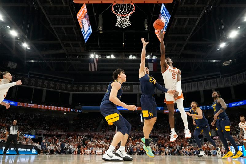 Feb 11, 2023; Austin, Texas, USA; Texas Longhorns guard Marcus Carr (5) lays in a basket over West Virginia Mountaineers forwards Patrick Suemnick (24) and James Okonkwo (32) during the second half at Moody Center. Mandatory Credit: Scott Wachter-USA TODAY Sports ac