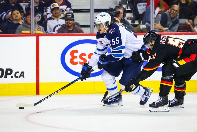 Oct 26, 2024; Calgary, Alberta, CAN; Winnipeg Jets center Mark Scheifele (55) skates with the puck against Calgary Flames defenseman MacKenzie Weegar (52) during the third period at Scotiabank Saddledome. Mandatory Credit: Sergei Belski-Imagn Images