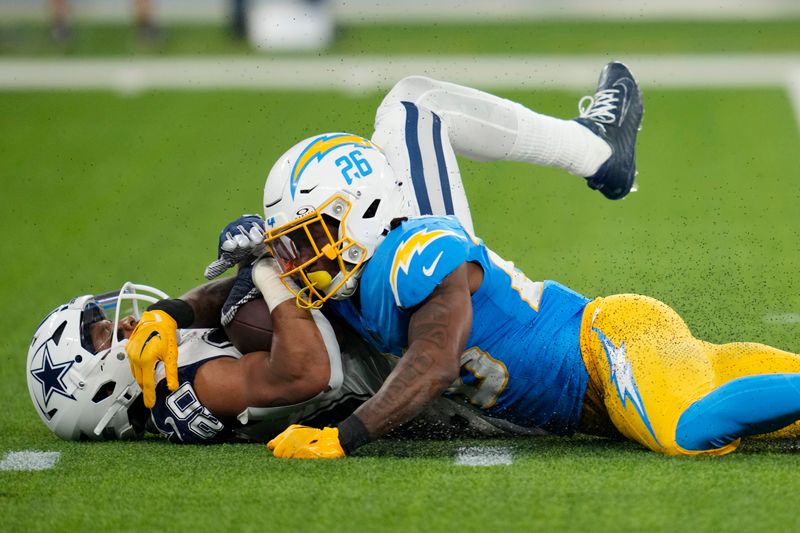 Dallas Cowboys running back Tony Pollard (20) is a tackled by Los Angeles Chargers cornerback Asante Samuel Jr. (26) during the second half of an NFL football game Monday, Oct. 16, 2023, in Inglewood, Calif. (AP Photo/Ashley Landis)