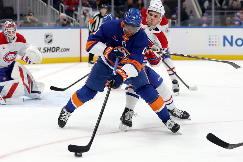 Mar 20, 2025; Elmont, New York, USA; New York Islanders left wing Anthony Duclair (11) skates with the puck against Montreal Canadiens left wing Juraj Slafkovsky (20) during the second period at UBS Arena. Mandatory Credit: Brad Penner-Imagn Images