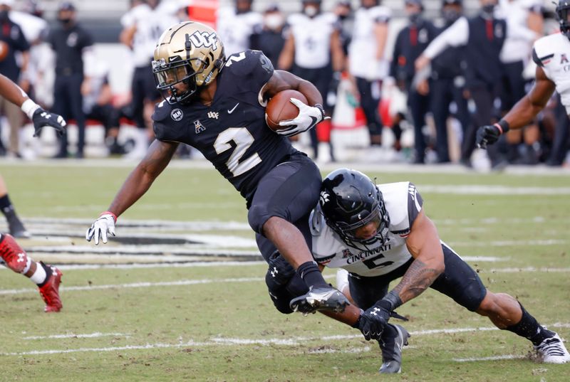 Nov 21, 2020; Orlando, Florida, USA; Cincinnati Bearcats wide receiver Jordan Jones (5) tackles UCF Knights running back Otis Anderson (2) on a punt play during the first quarter at the Bounce House. Mandatory Credit: Reinhold Matay-USA TODAY Sports