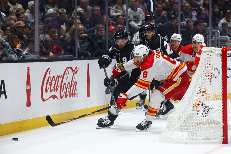 Dec 23, 2023; Los Angeles, California, USA; Los Angeles Kings right wing Adrian Kempe (9) fights for the puck against Calgary Flames defenseman Chris Tanev (8) during the second period of a game at Crypto.com Arena. Mandatory Credit: Jessica Alcheh-USA TODAY Sports